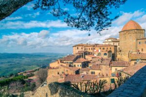 Panoramic view of Volterra's historic architecture and scenic landscape under a clear sky.